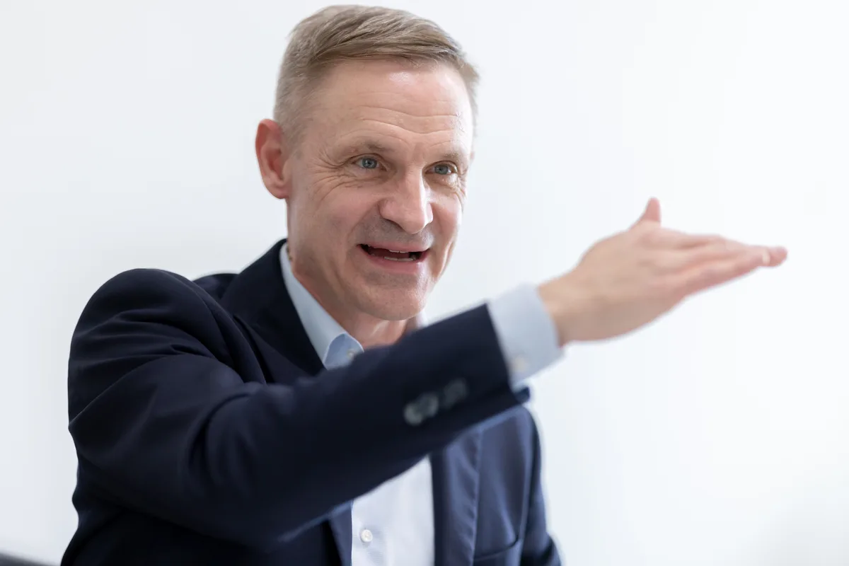 Ein Mann im Anzug gestikuliert. 